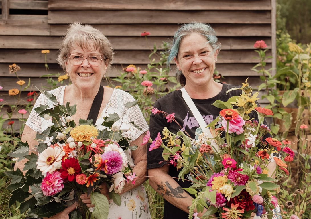 Two women proudly displaying their beautiful bouquets of freshly picked flowers at Cedar Creek Farm Hunter Valley.