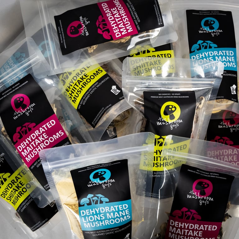 A collection of branded pouches containing dehydrated mushrooms and mushroom powders from The Mushroom Guys.